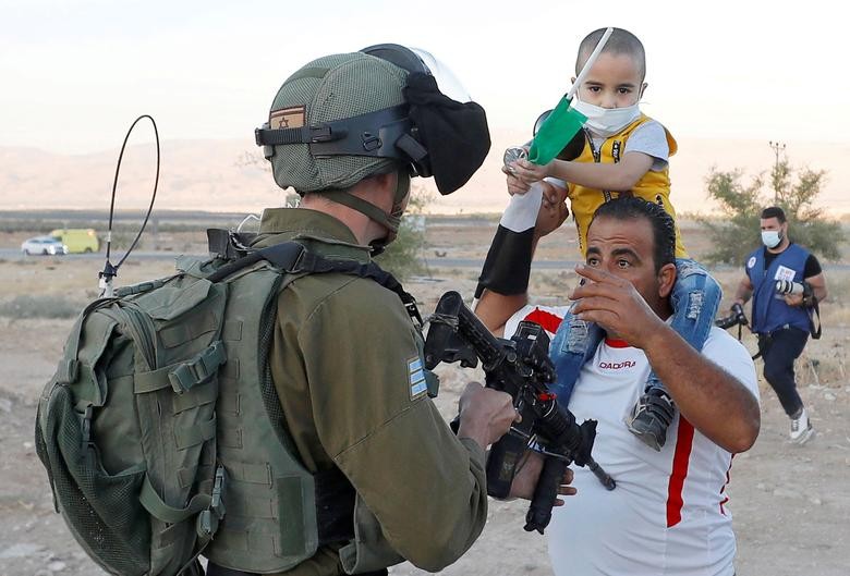 A Palestinian man argues with an Israeli soldier during a protest against Israel's plan to annex parts of the occupied West Bank, in Jordan Valley. REUTERS/Mohamad Torokman  